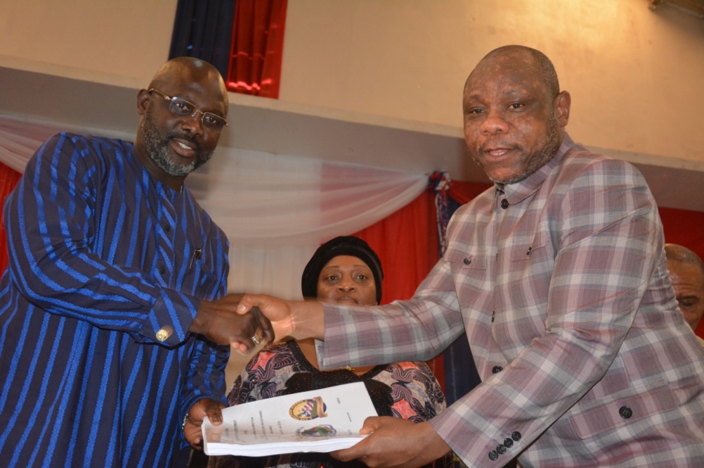 Liberia President George Weah receiving a copy of Pro-Poor Agenda for Prosperity and Development