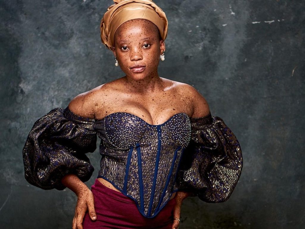 Adelaja Ewawunmi in gold head-tie, off-shoulder blouse, and wine skirt (Image Source: Instagram)