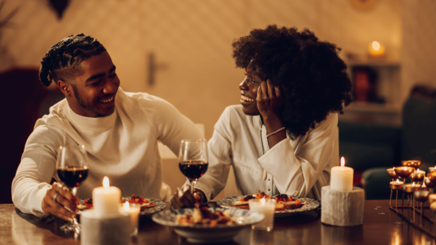 couple enjoying a Valentine's Day dinner at a beautifully decorated table featuring African cuisine.