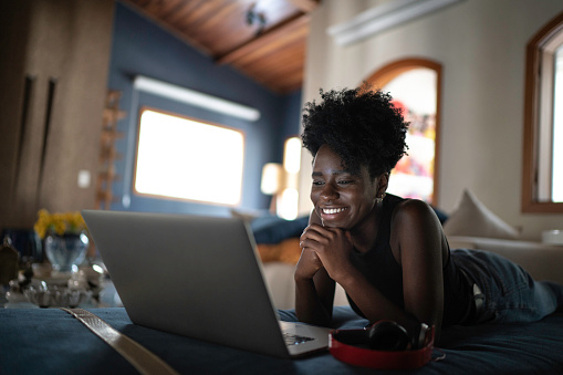 Young women watching movie on a laptop at home